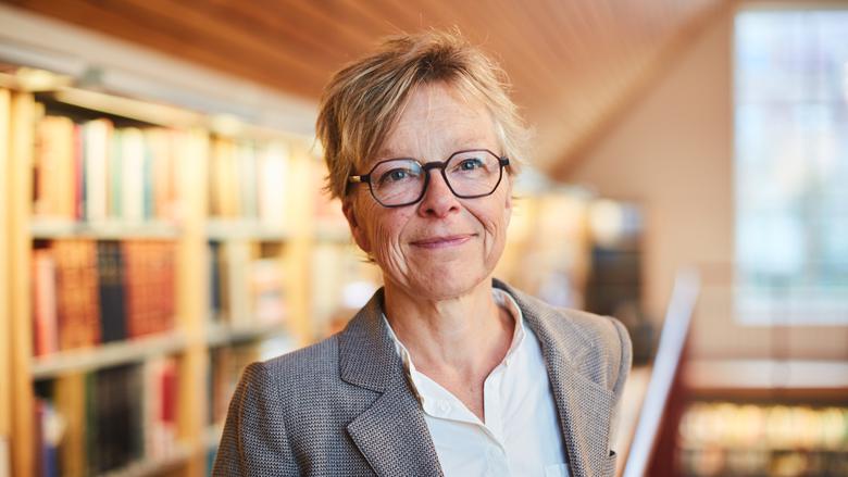 Porträttfoto på Lomma kommuns nya bibliotekschef Susann Ek som har grå kavaj med ljus blus och svarta glasögonbågar.