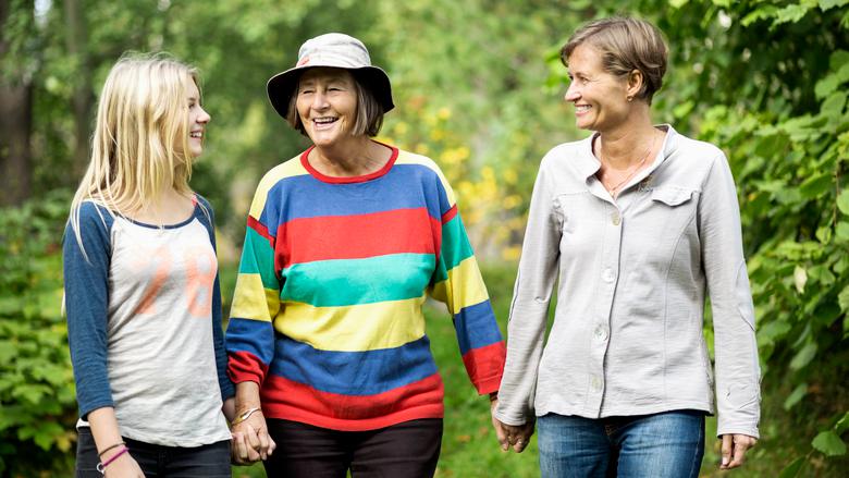Tre kvinnor i olika åldrar går på en skogsstig