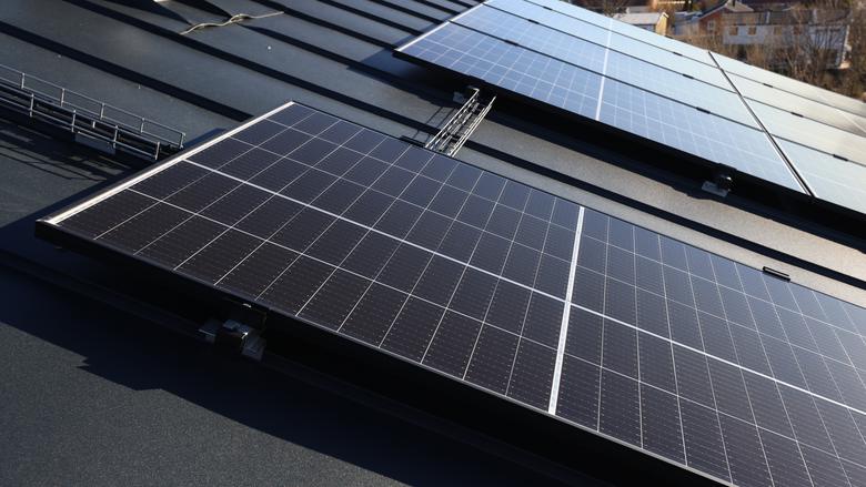 Stora svarta fyrkantiga block med solceller ligger monterade på ett tak