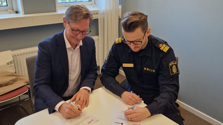 Robert Wenglén, kommunstyrelsens ordförande och Freddy Nilsson, lokalpolisområdeschef signerar överenskommelsen.