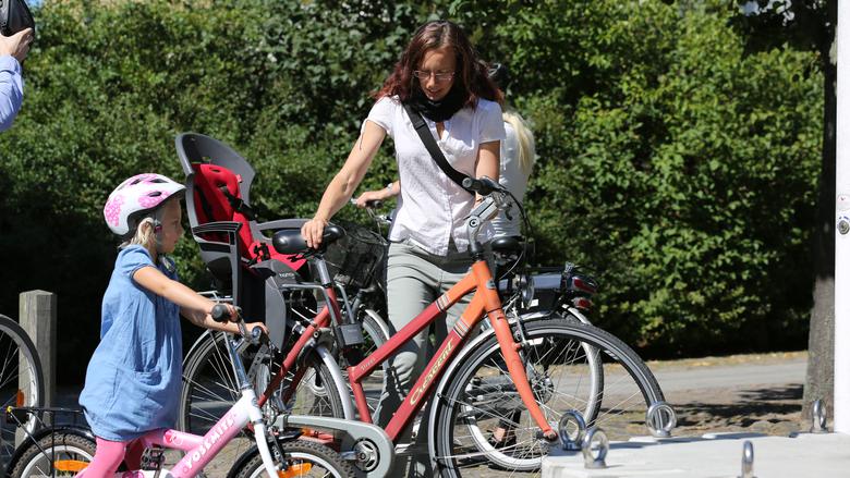 Förälder och barn parkerar sina cyklar