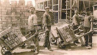 Arbetare med skottkärror fulla med tegelstenar. ca 1914.