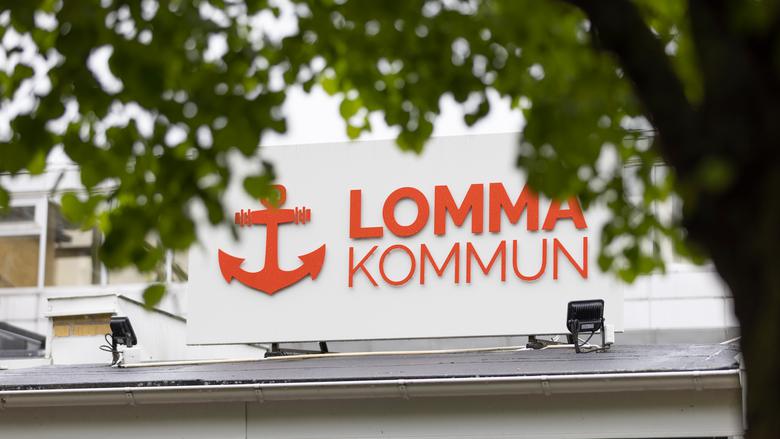Vit skylt med Lomma kommuns namn och logotyp i form av ett rött ankare.