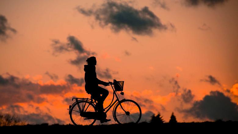 Person som cyklar i solnedgången